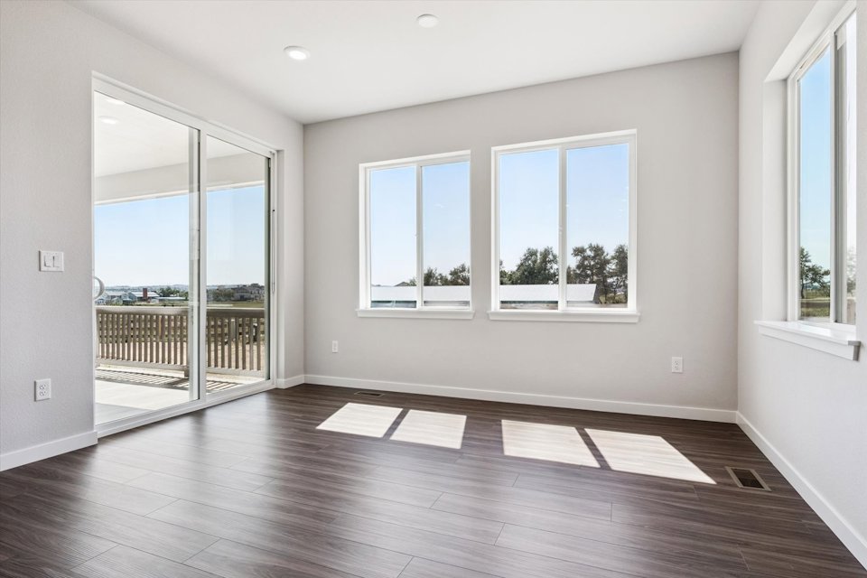 A room with windows and a wood floor.