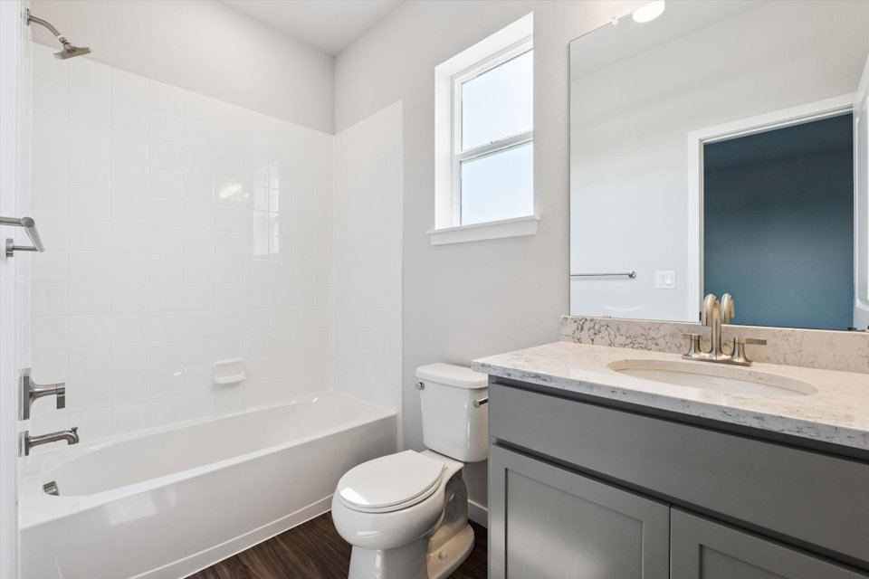 A bathroom with a tub sink and toilet.