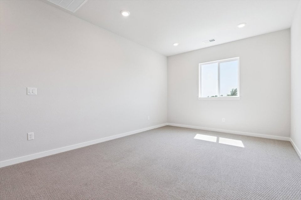A room with a window and a white wall.