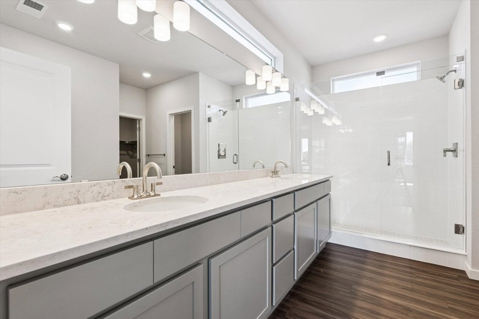 A bathroom with a sink and a shower unit.