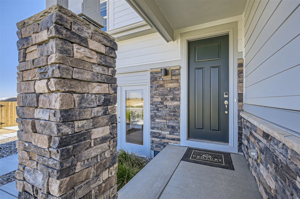 A stone building with a door and a stone wall.