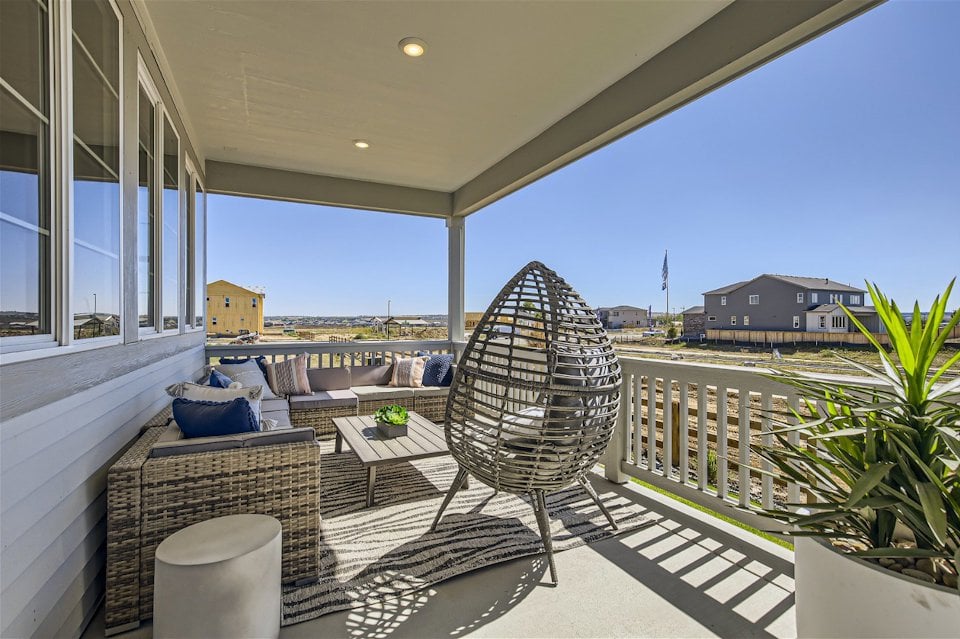 A patio with a chair and a table and chairs on it.