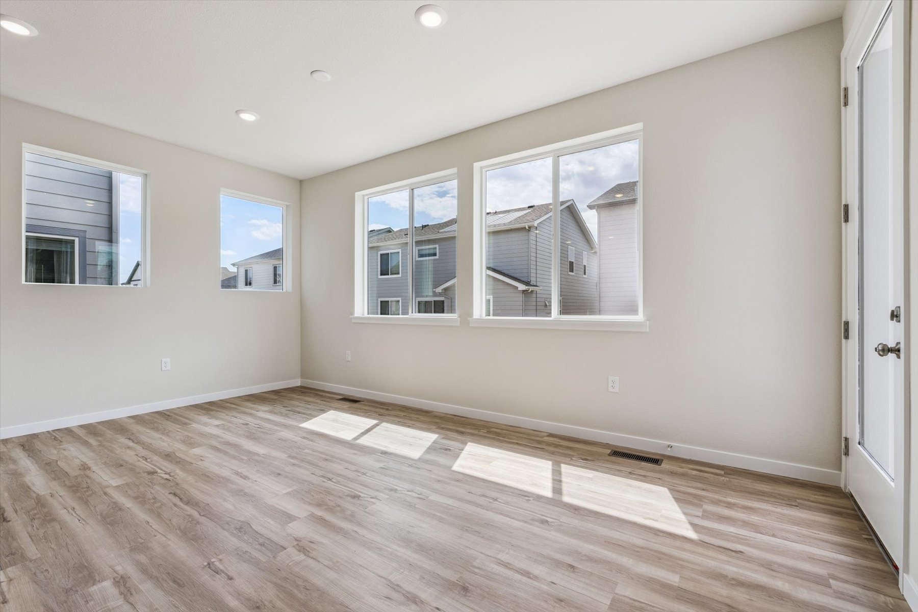 A room with a wood floor and a wood floor with a window.
