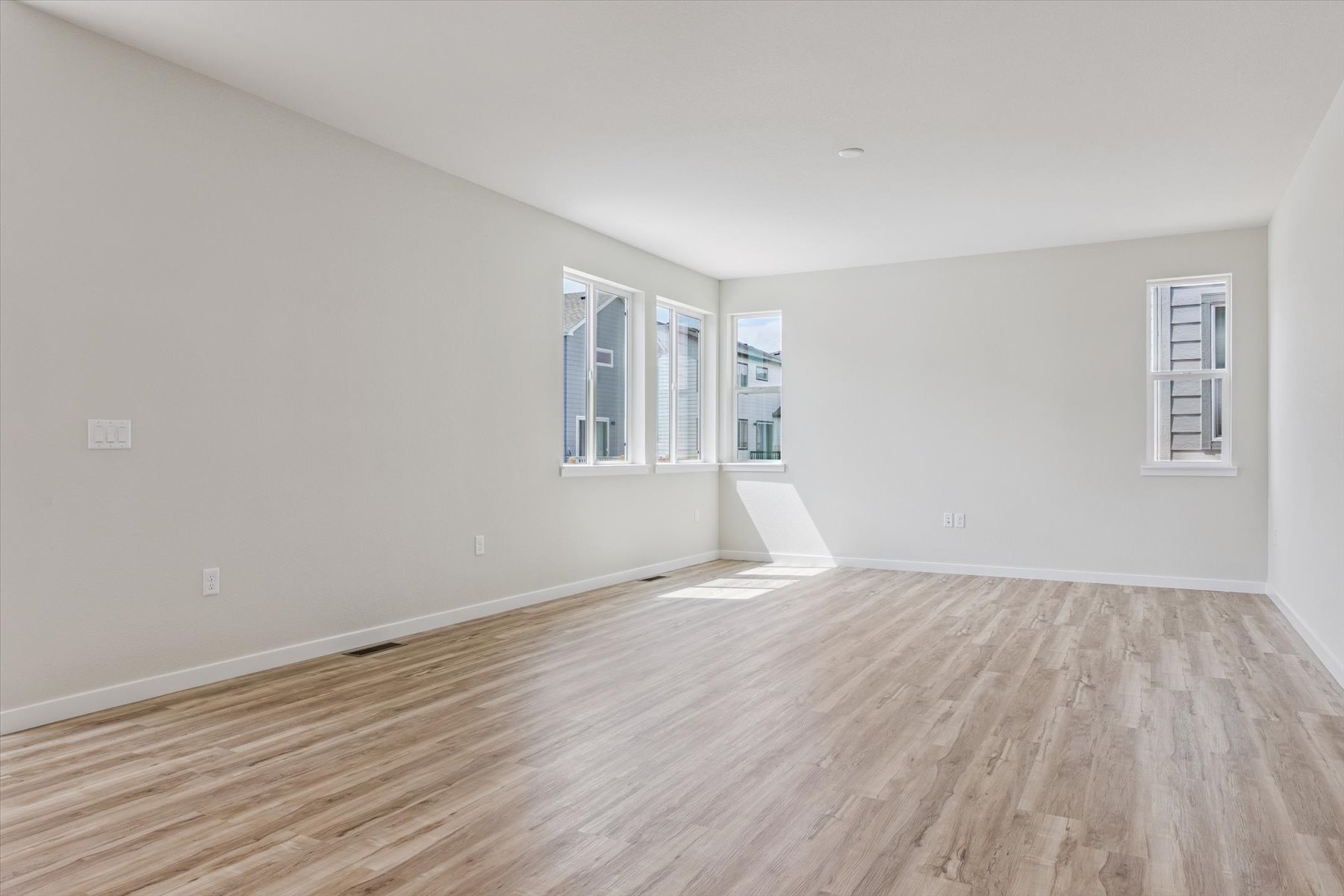 A room with a wood floor and windows.