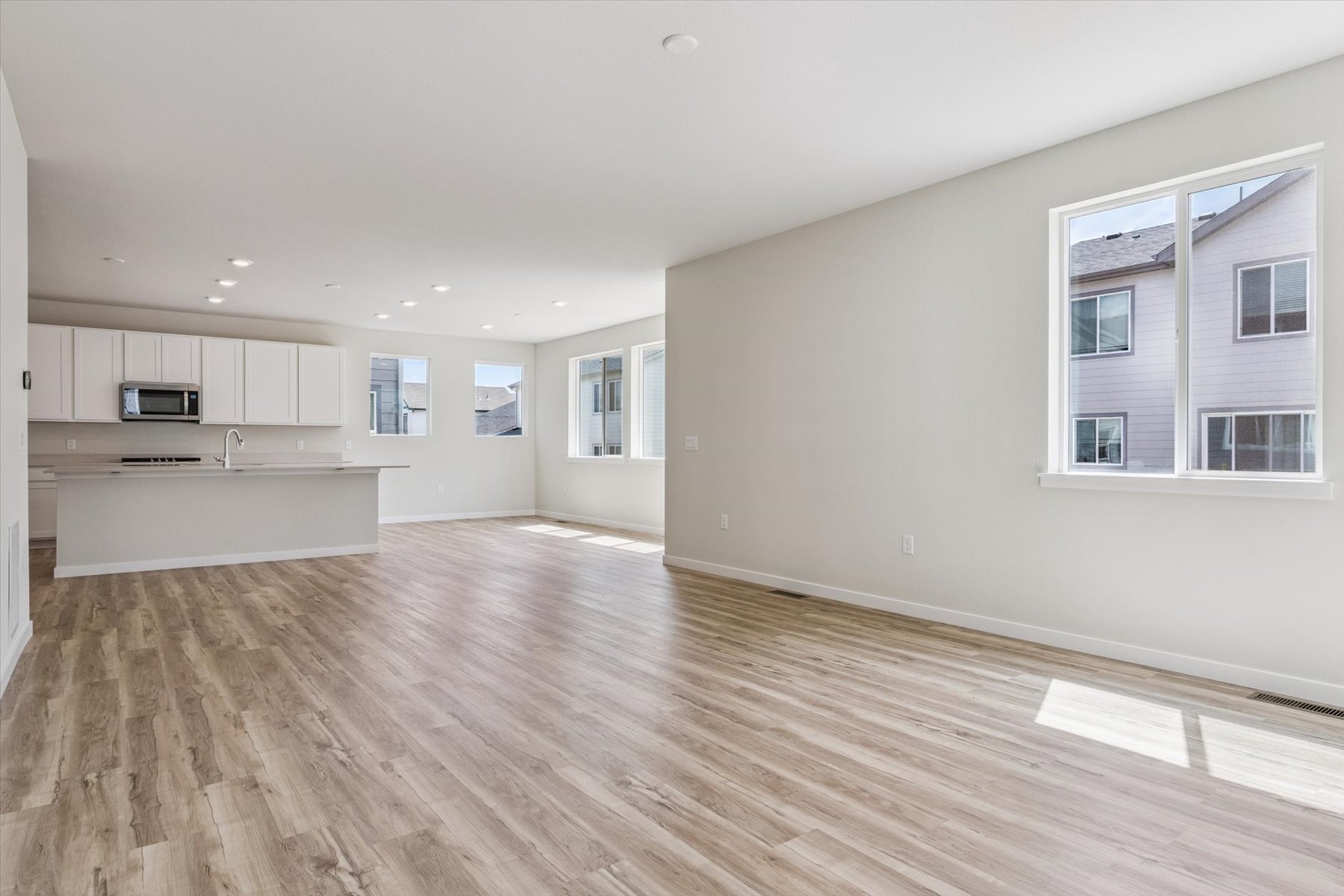 A large empty room with white cabinets.