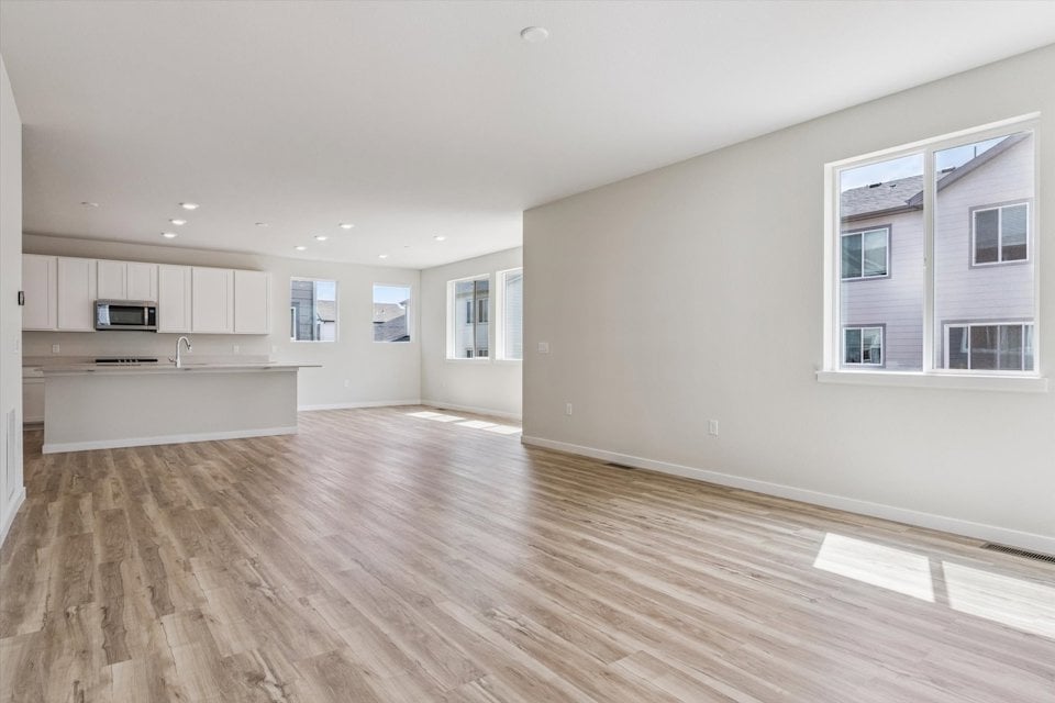 A large empty room with white cabinets.