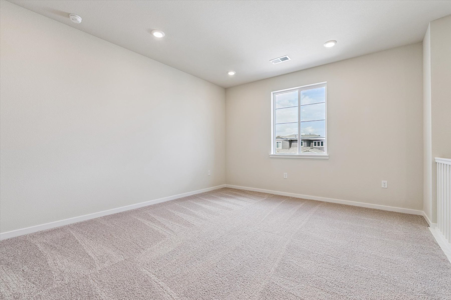 A room with a window and a carpet.