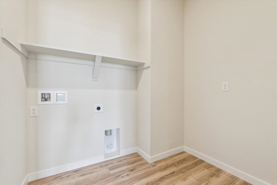 A white room with a wood floor and white walls.