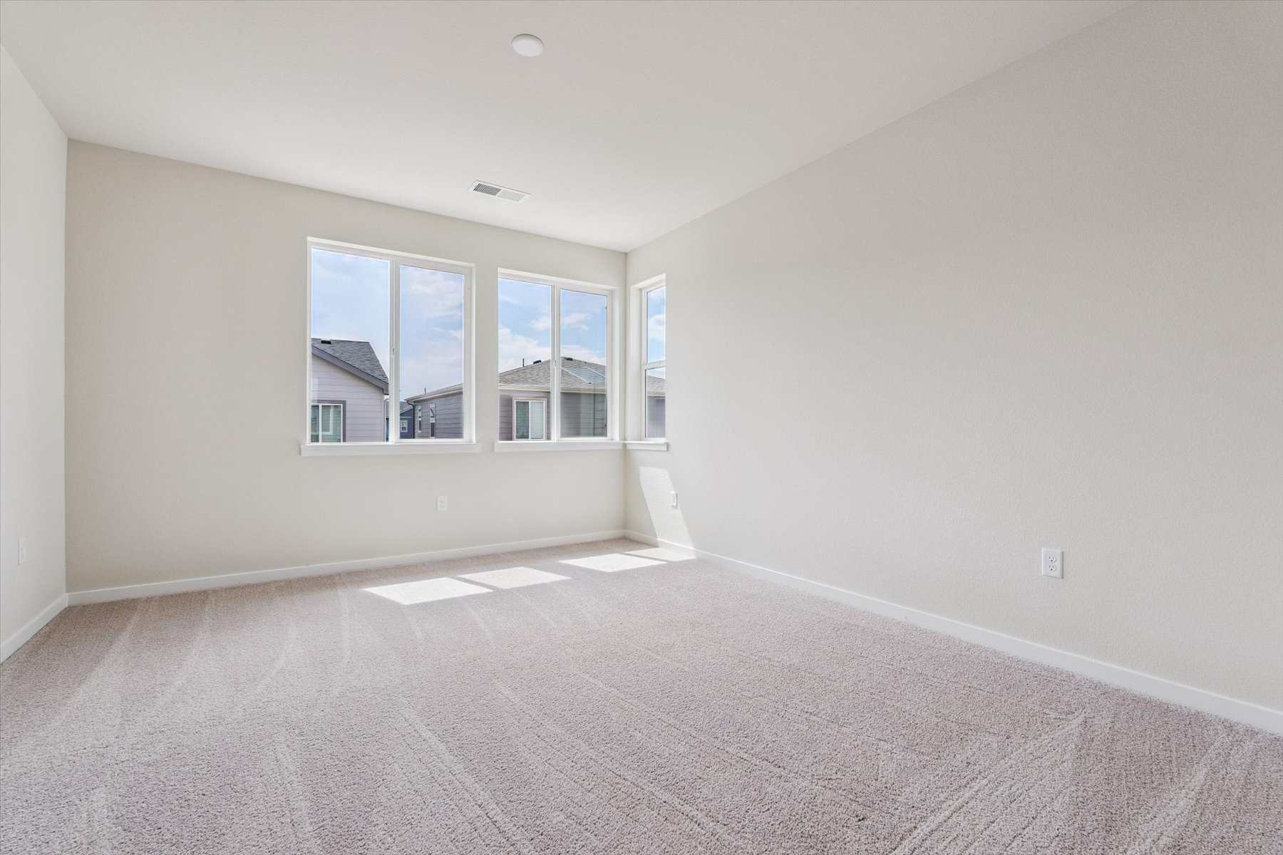 A room with a window and a carpet.