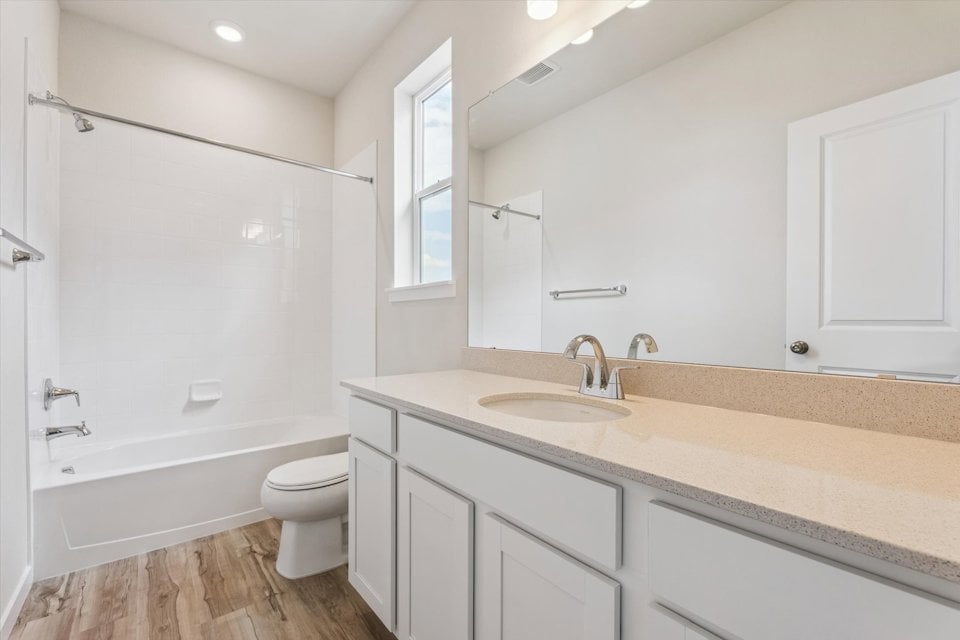 A bathroom with a tub sink and toilet.