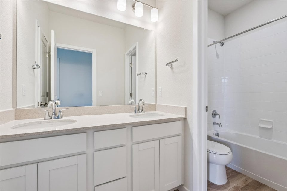 A bathroom with a tub sink and toilet.