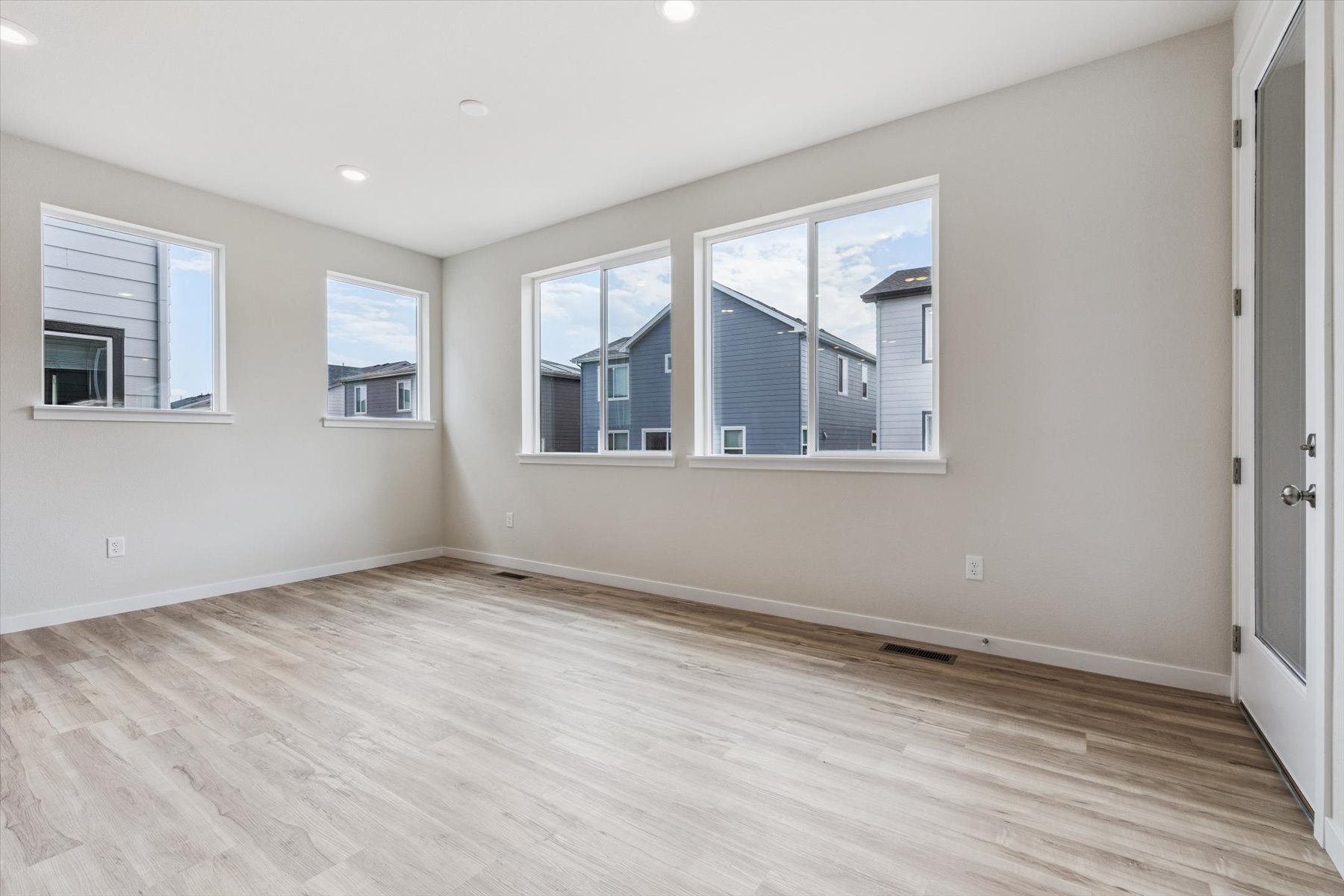 A room with a wood floor and windows.