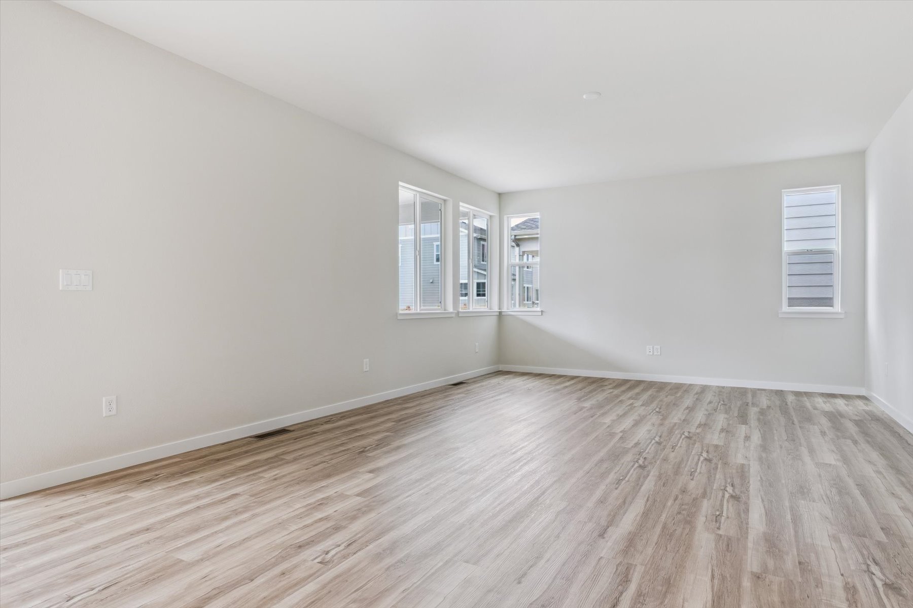 A room with a wood floor and windows.