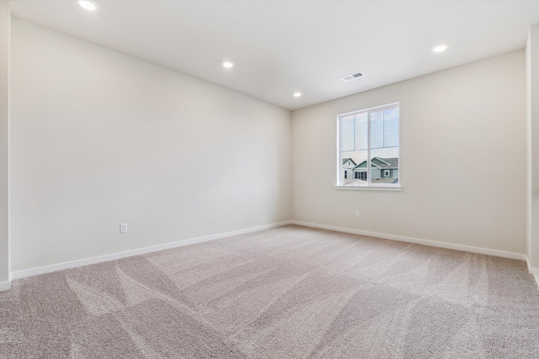A room with a window and carpet.
