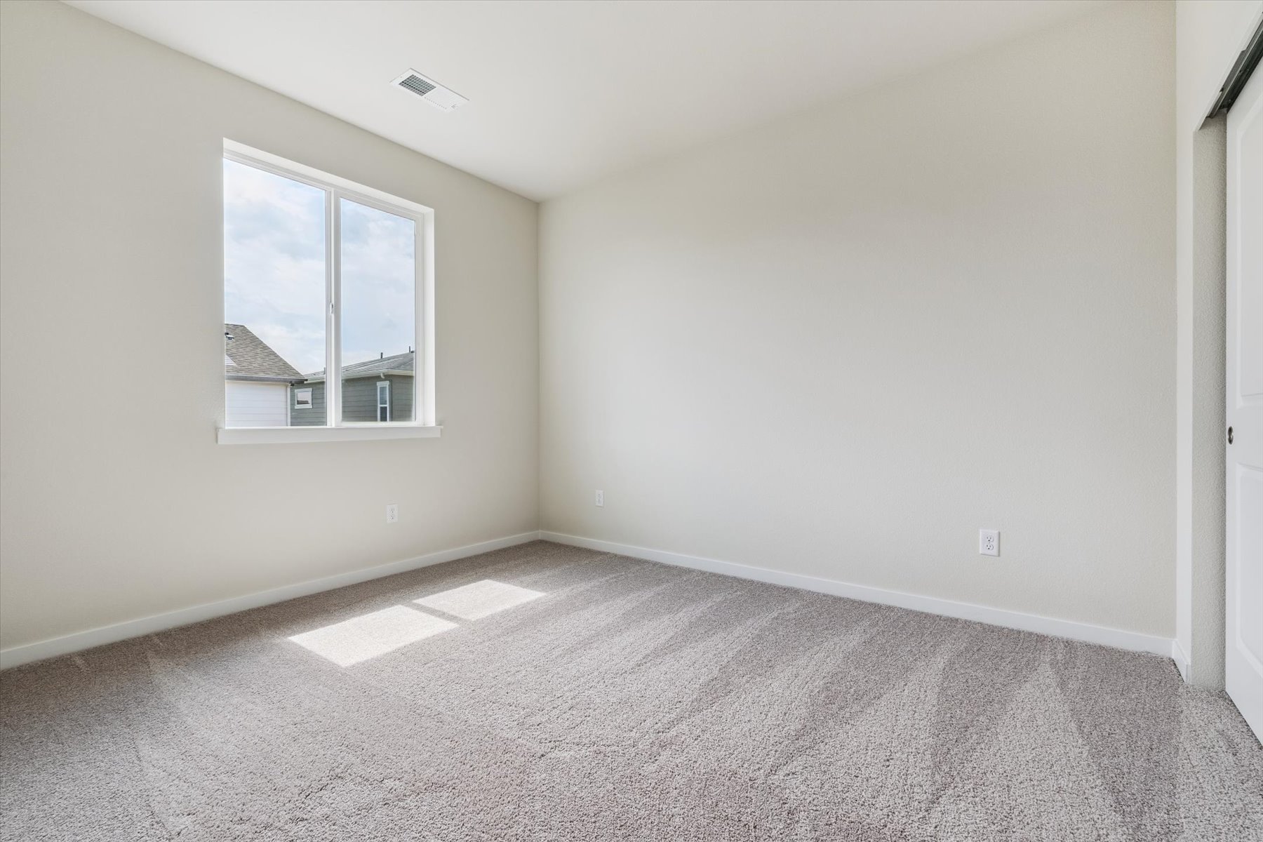 A room with a window and carpet.