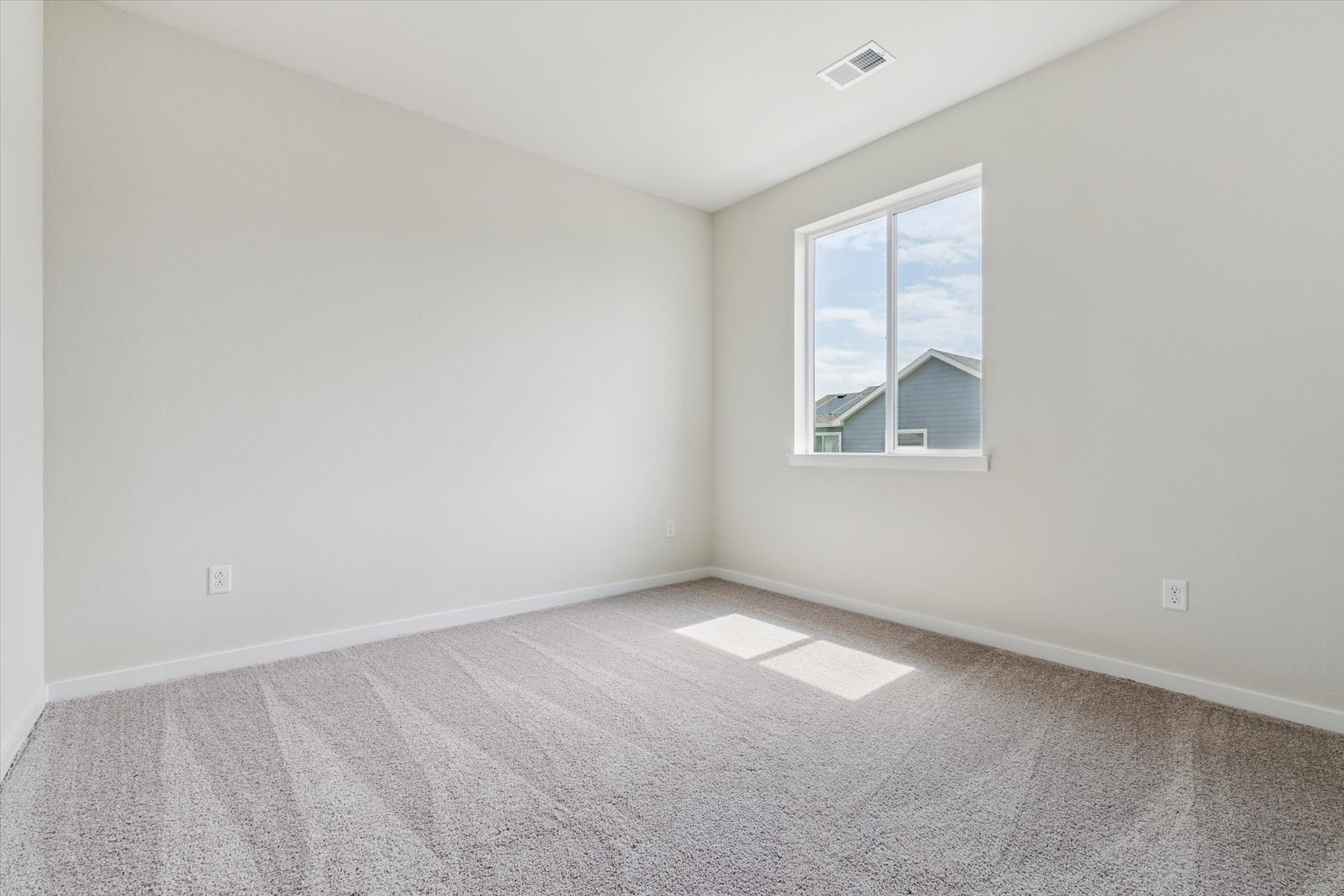 A room with a window and a carpet.