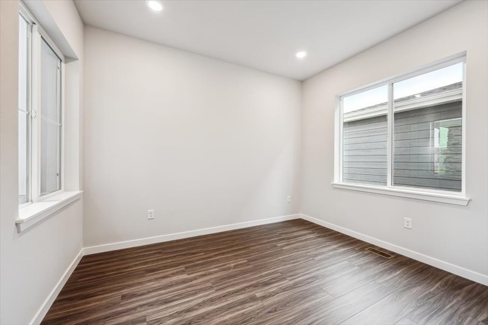 A room with a wood floor and a window.