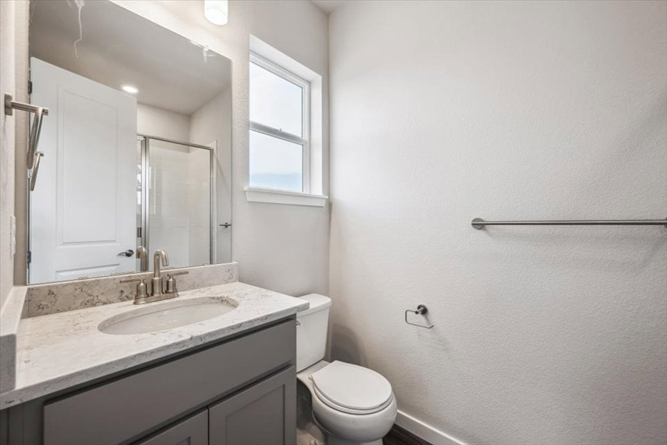A bathroom with a sink toilet and mirror.