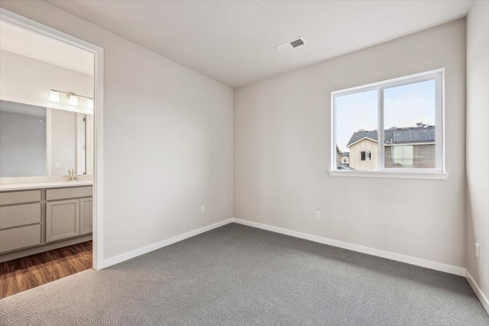 A room with a window and a carpet.