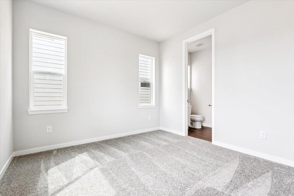 A bathroom with a toilet and a window.