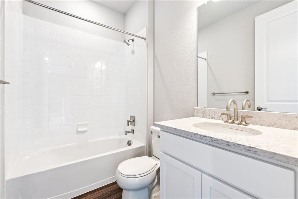 A bathroom with a tub sink and toilet.