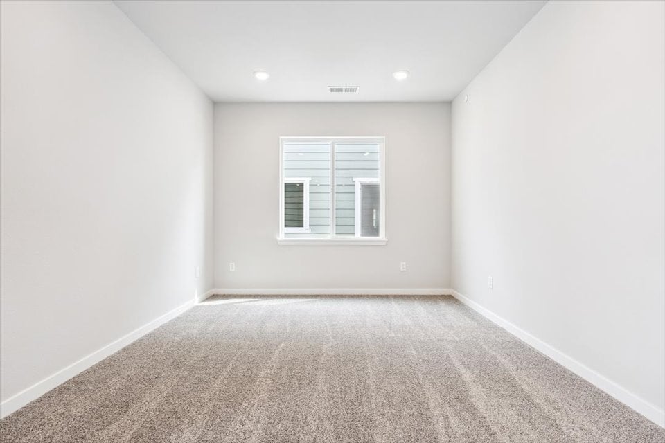 A room with a window and carpet.