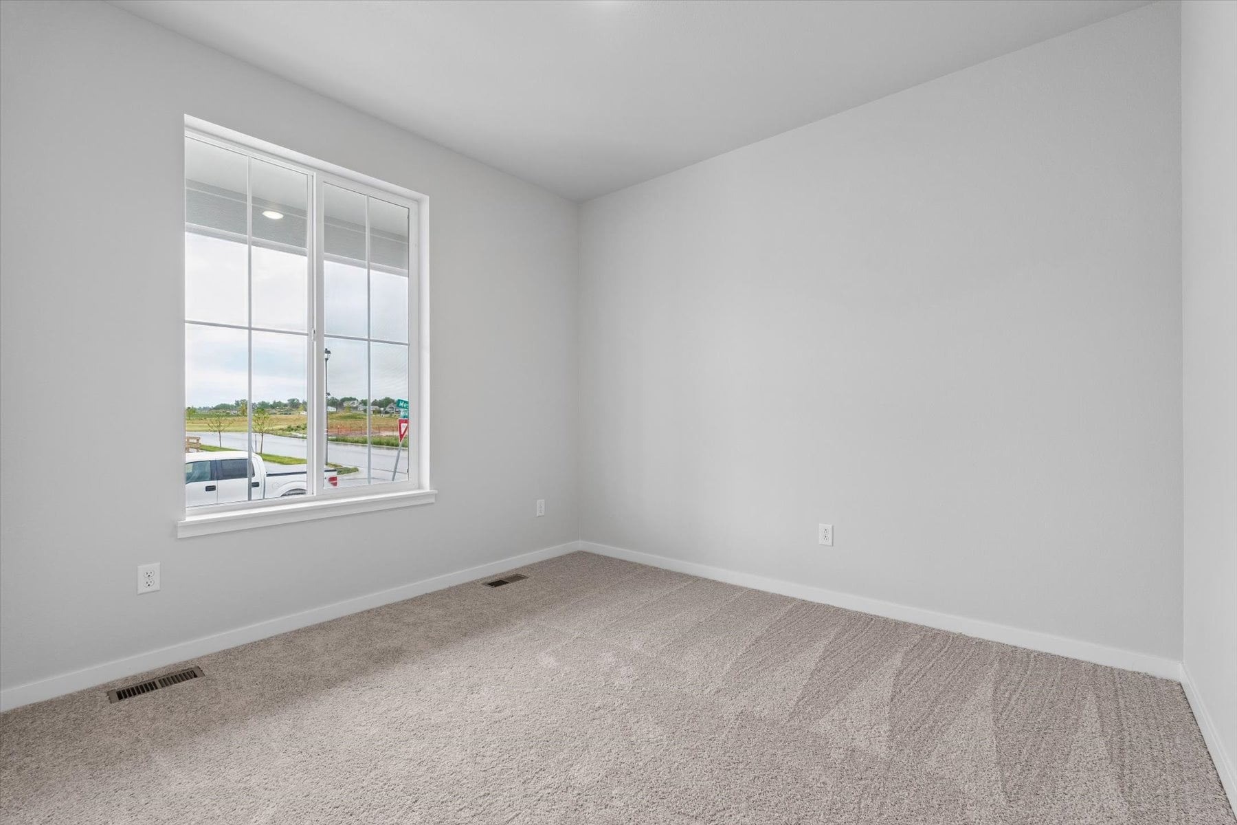 A room with a window and a carpet.