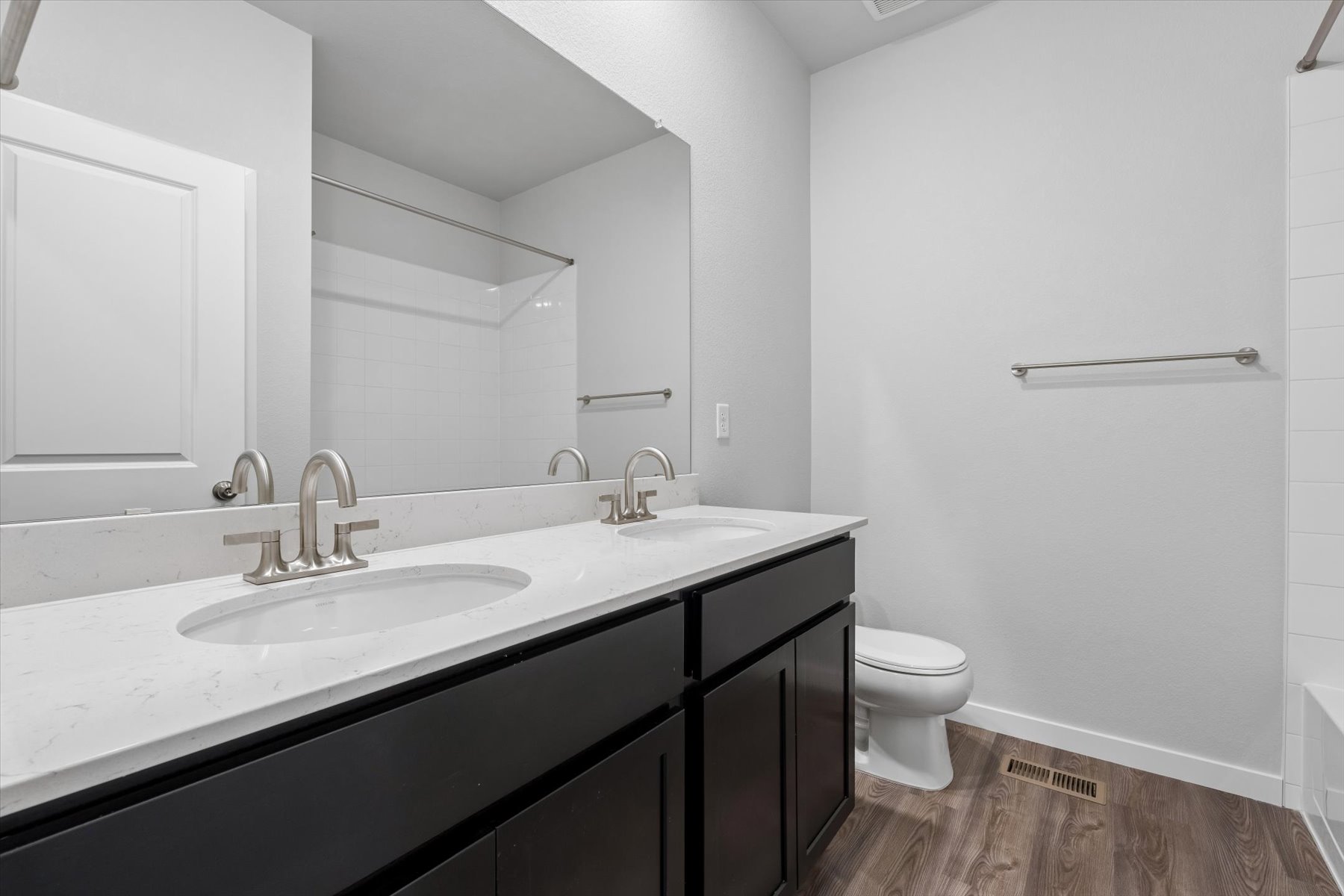 A bathroom with a sink toilet and mirror.