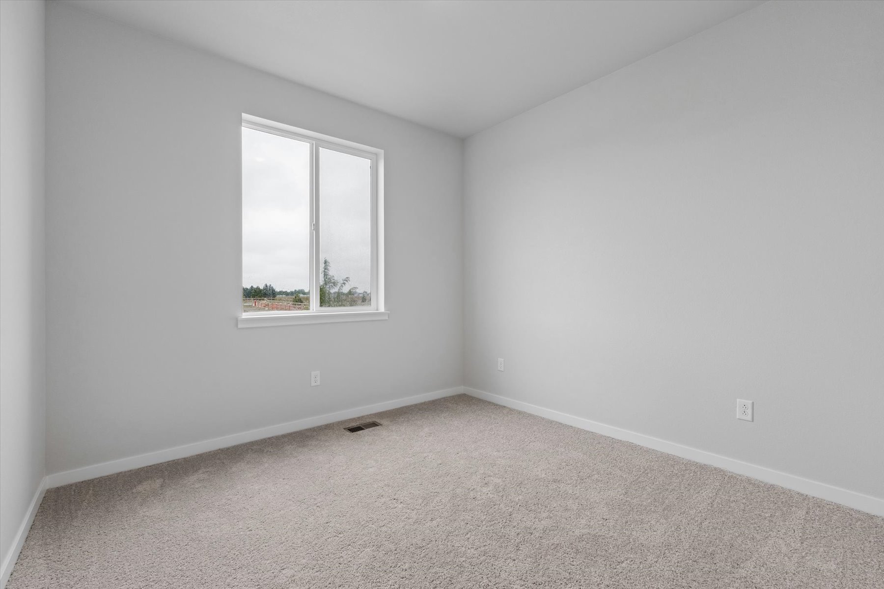 A room with a window and a carpet.