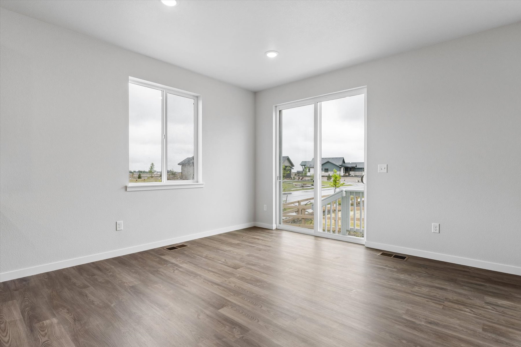 A room with a wood floor and a window with a wood floor.