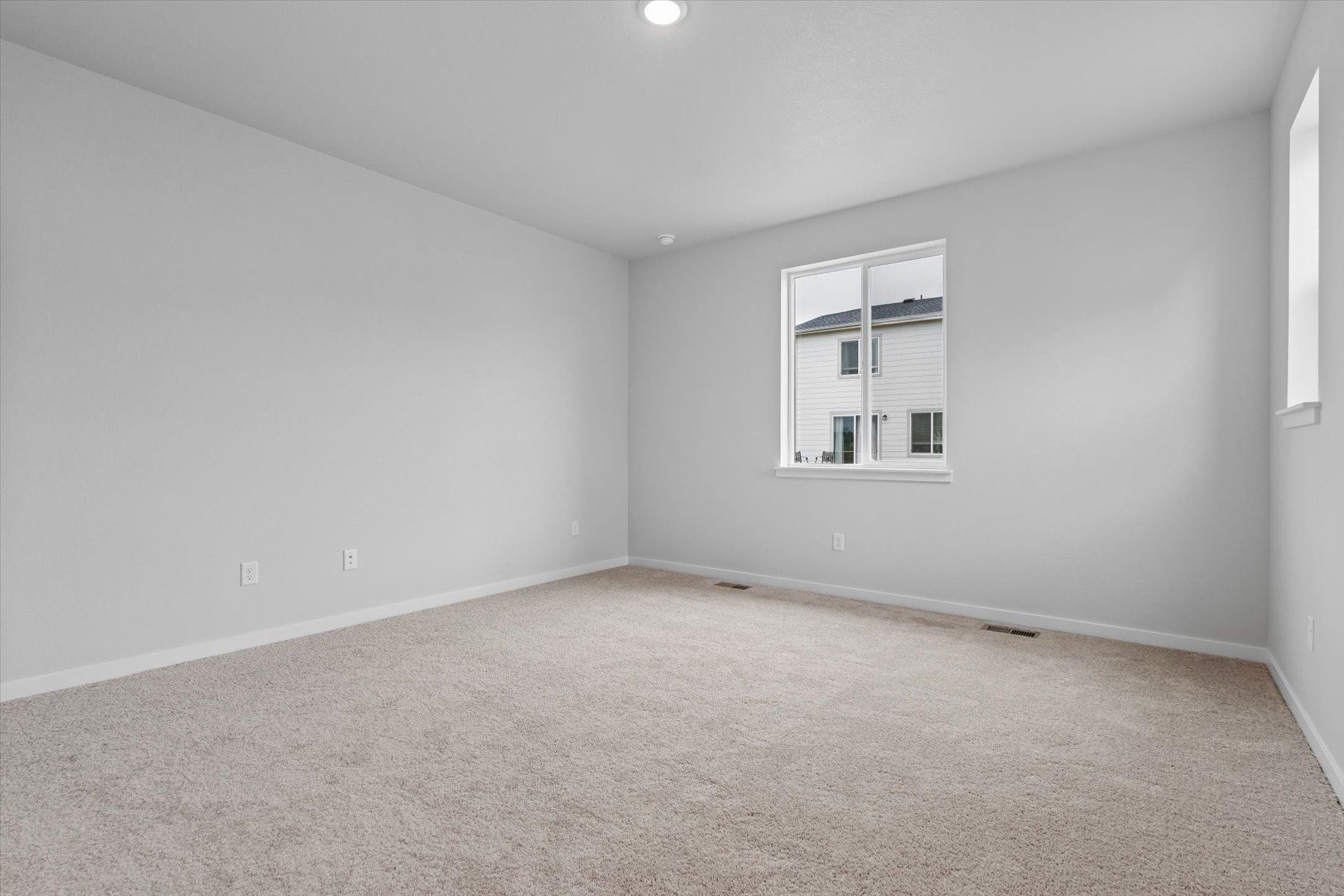 A room with a window and a carpet.