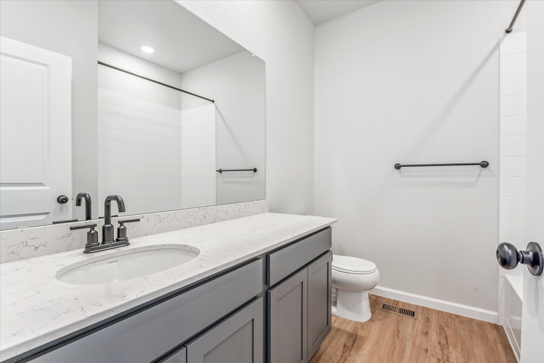 A bathroom with a sink toilet and mirror.