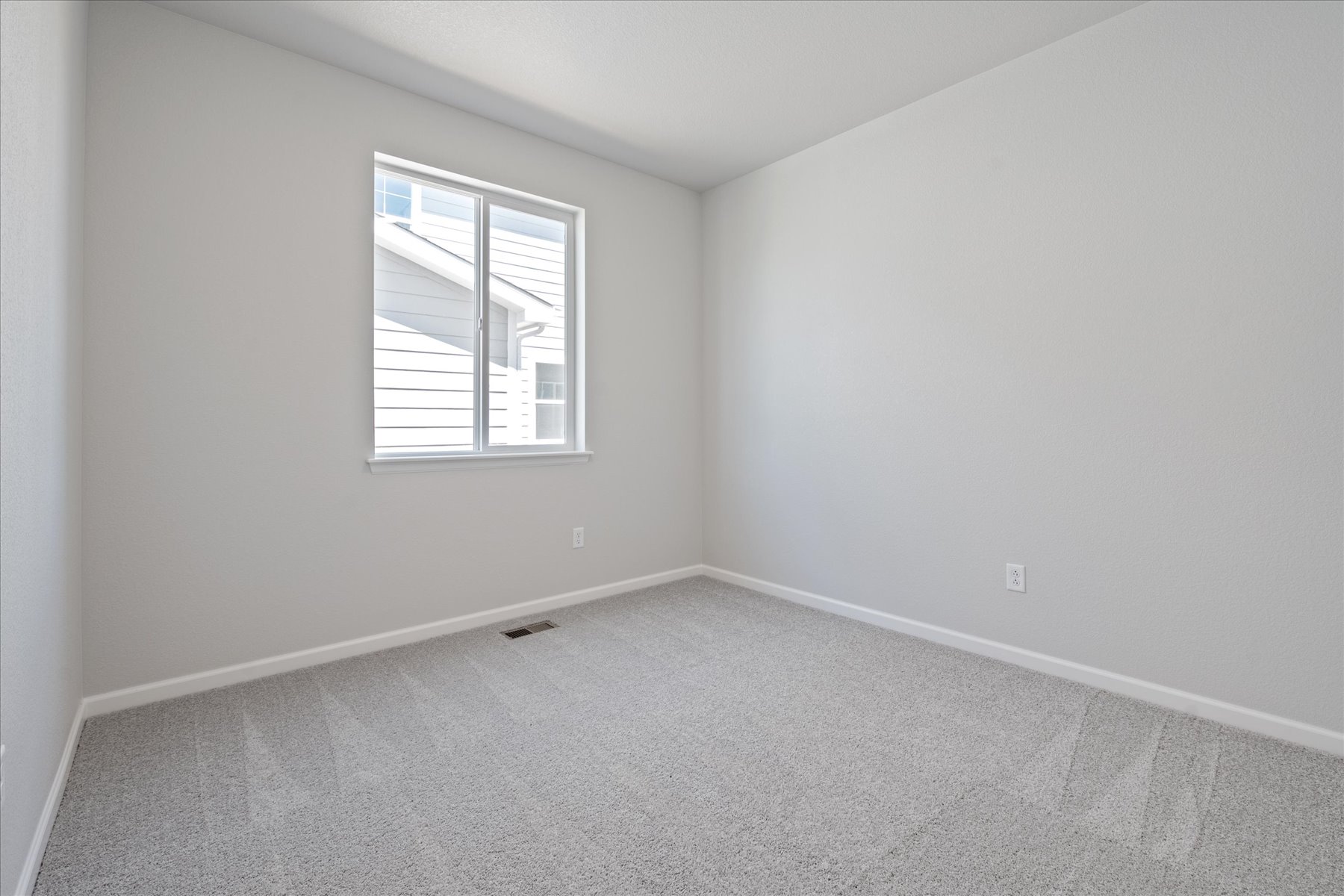 A room with a window and a carpet.