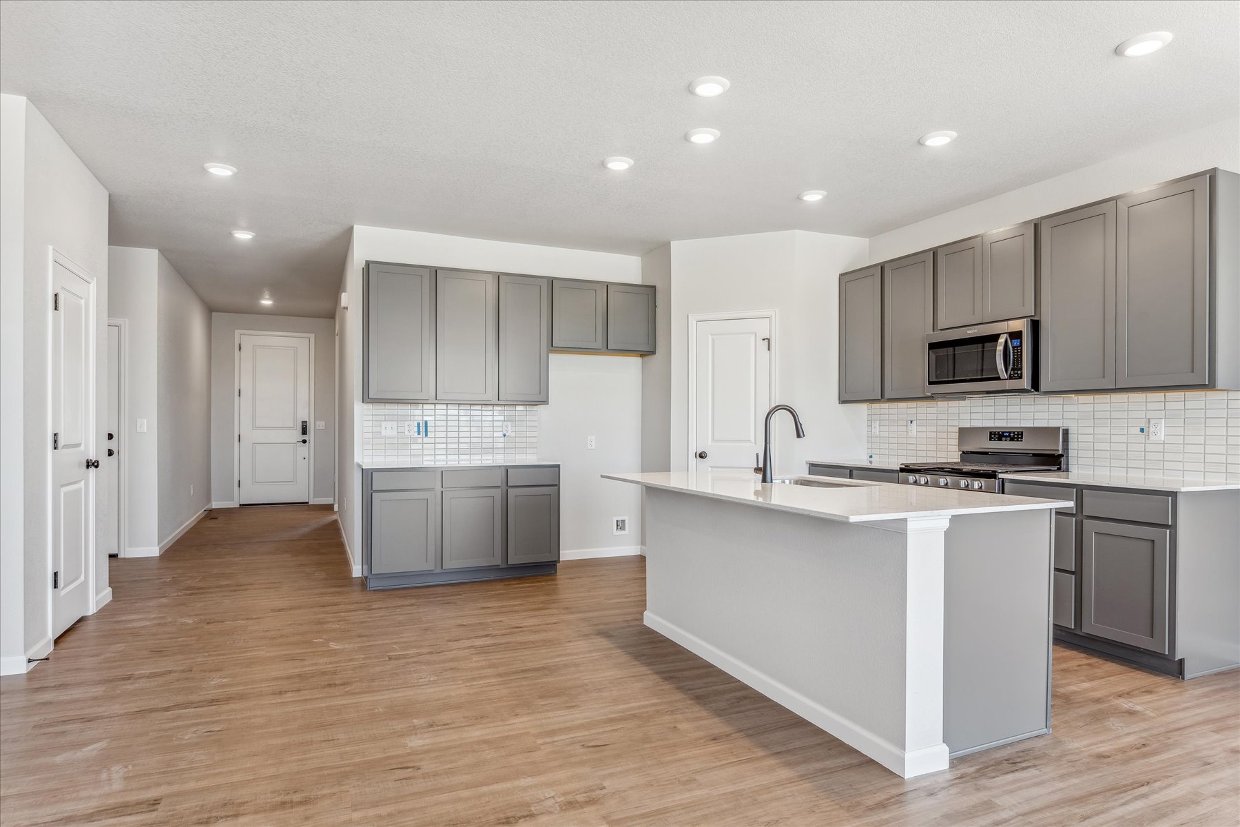 A kitchen with white cabinets.