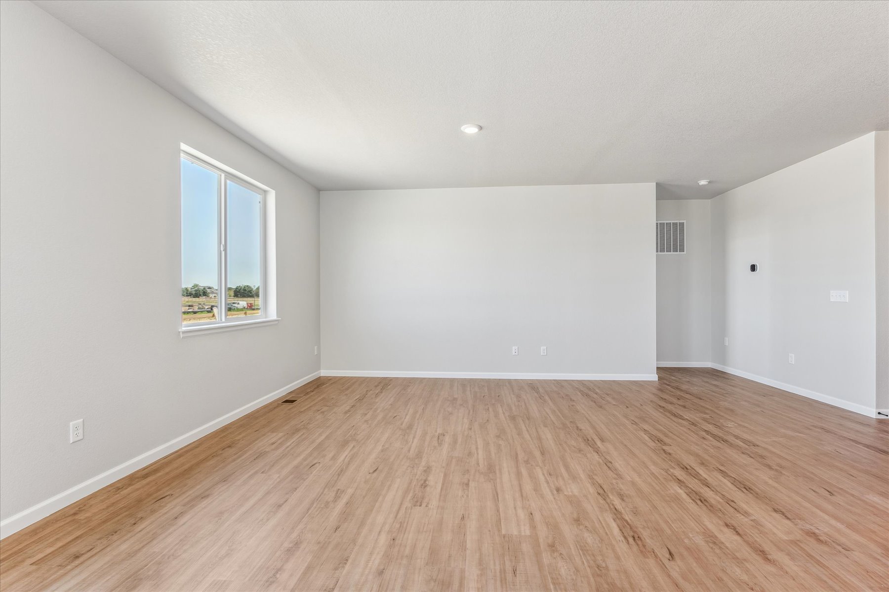 A room with a wood floor and a window.