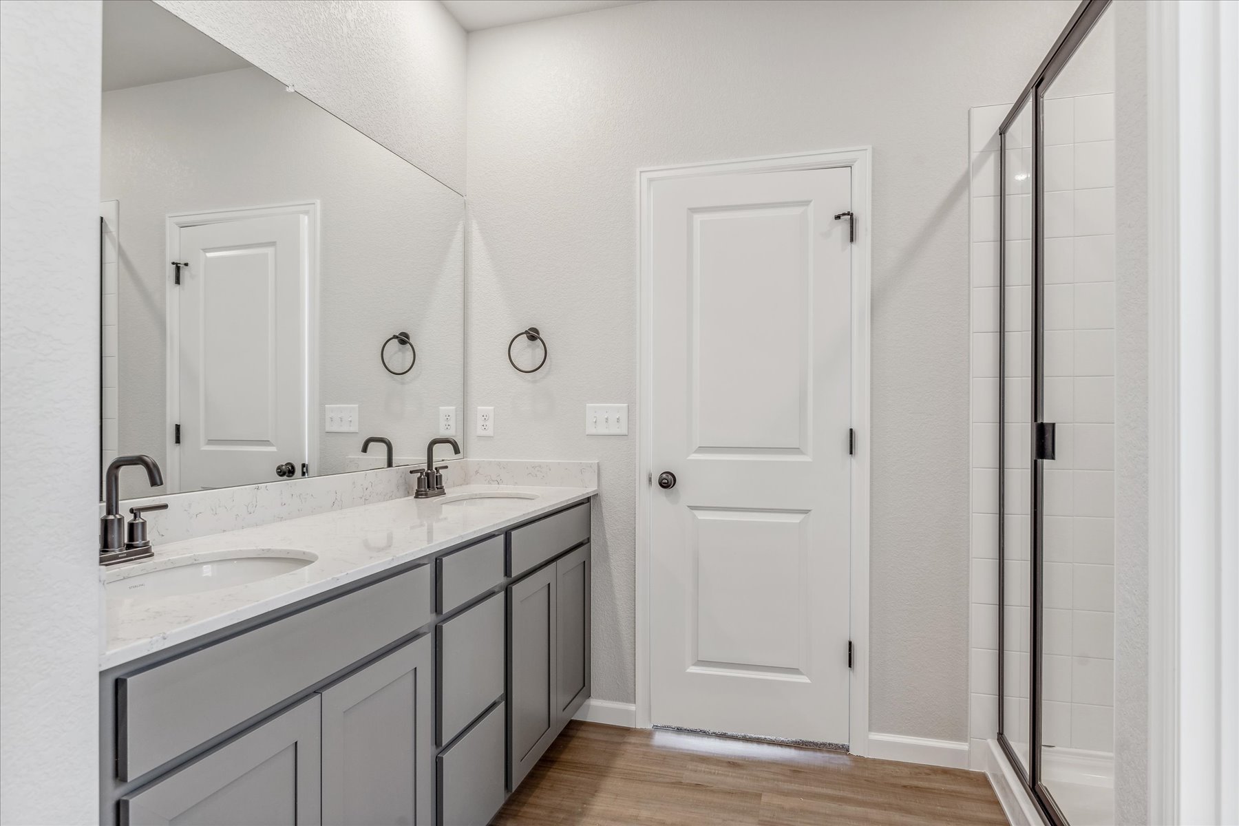 A bathroom with a sink and a shower unit.