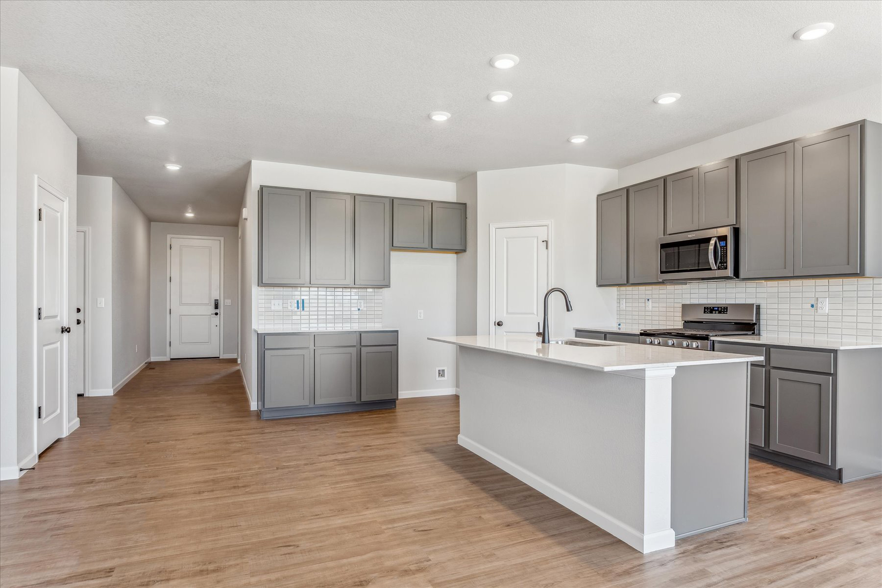 A kitchen with white cabinets.