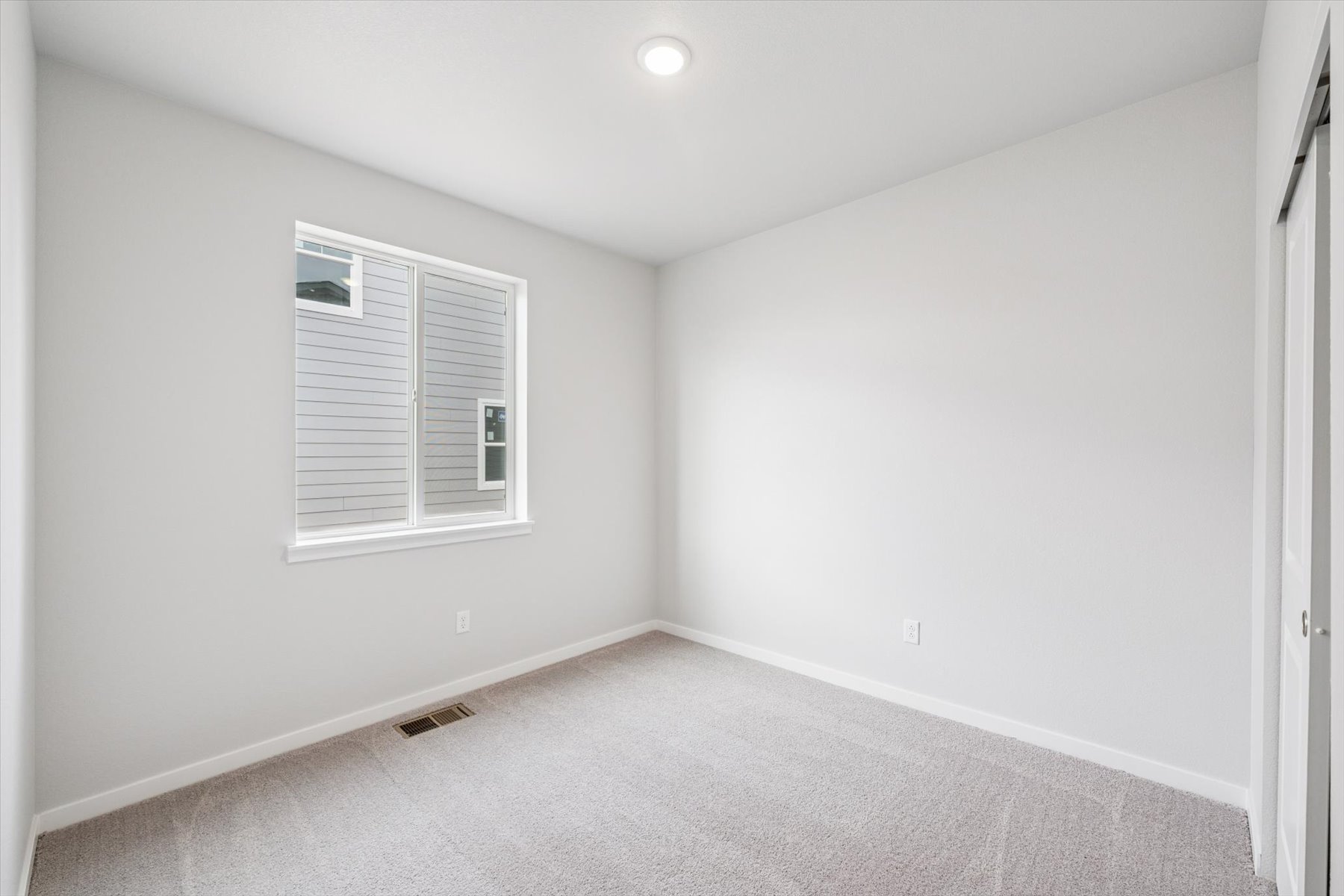 A room with a white wall and a window.