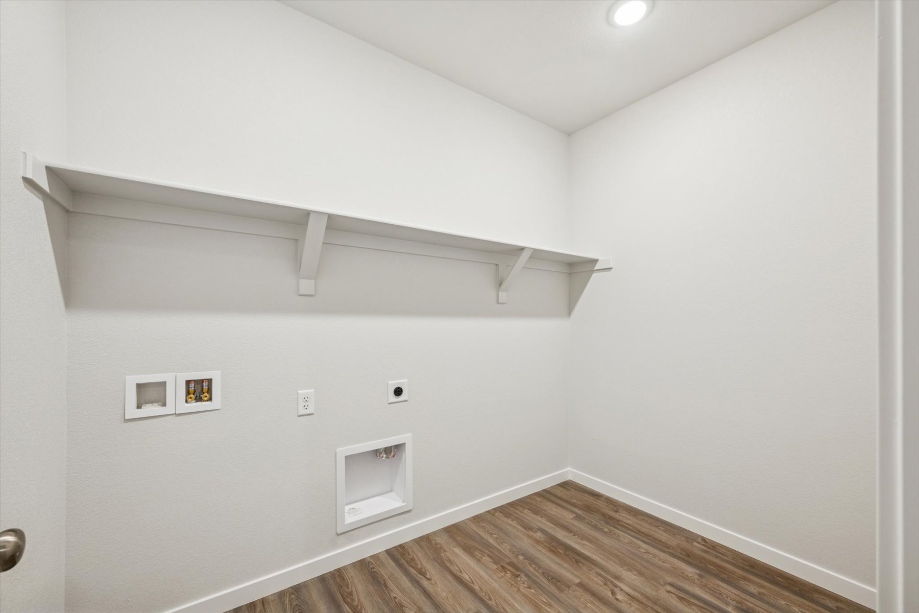 A white room with a wood floor.