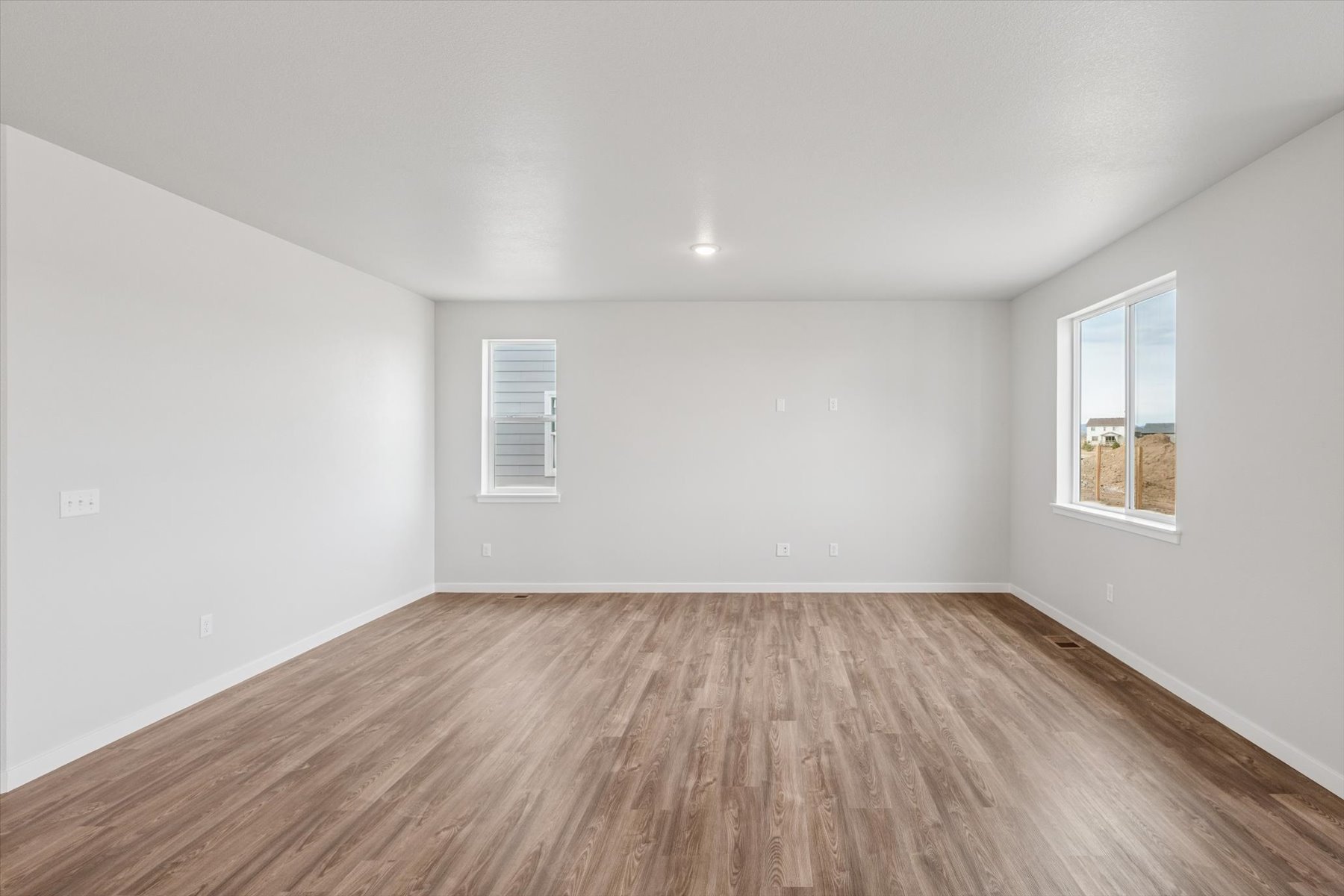 A room with a wood floor and windows.