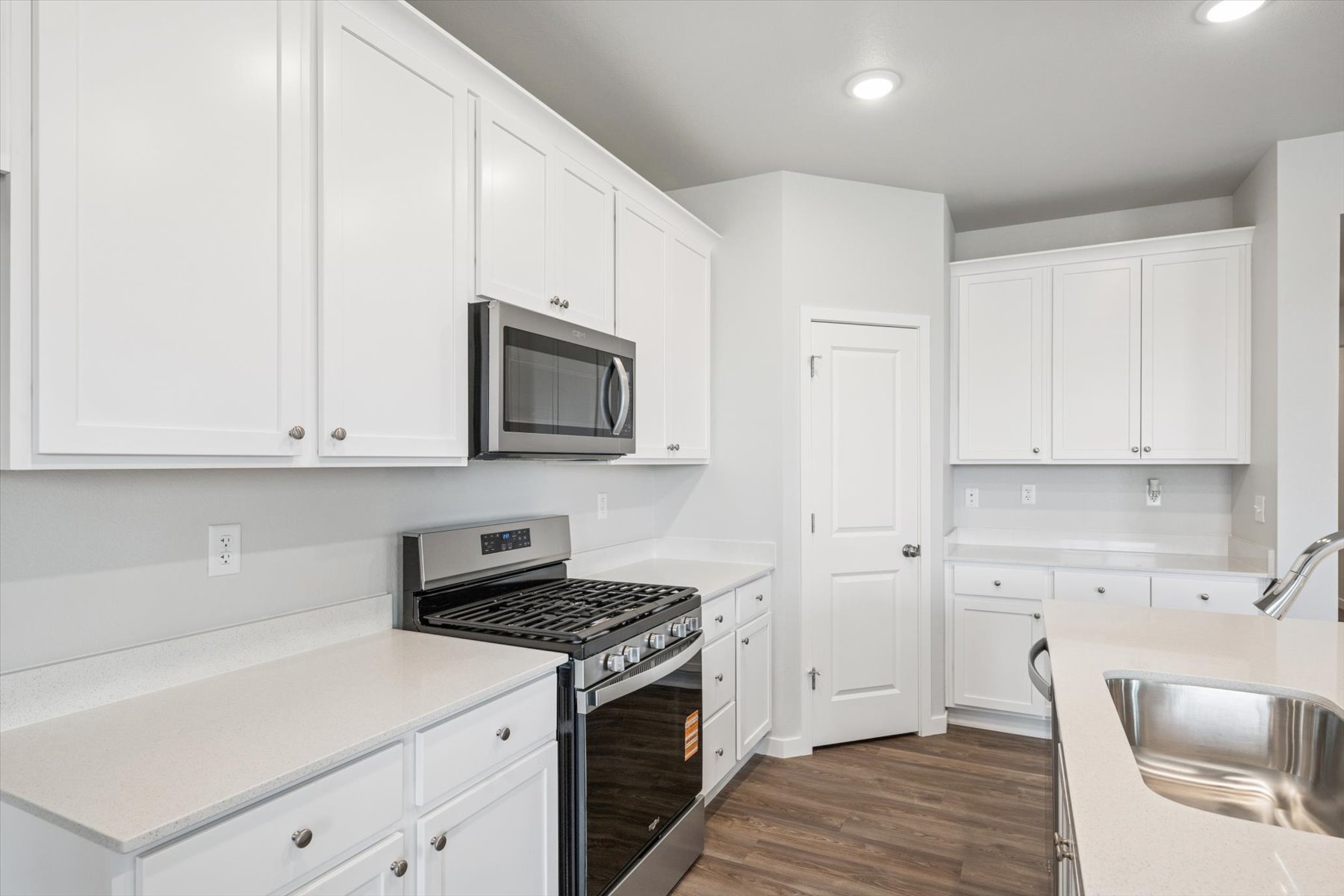 A kitchen with white cabinets.