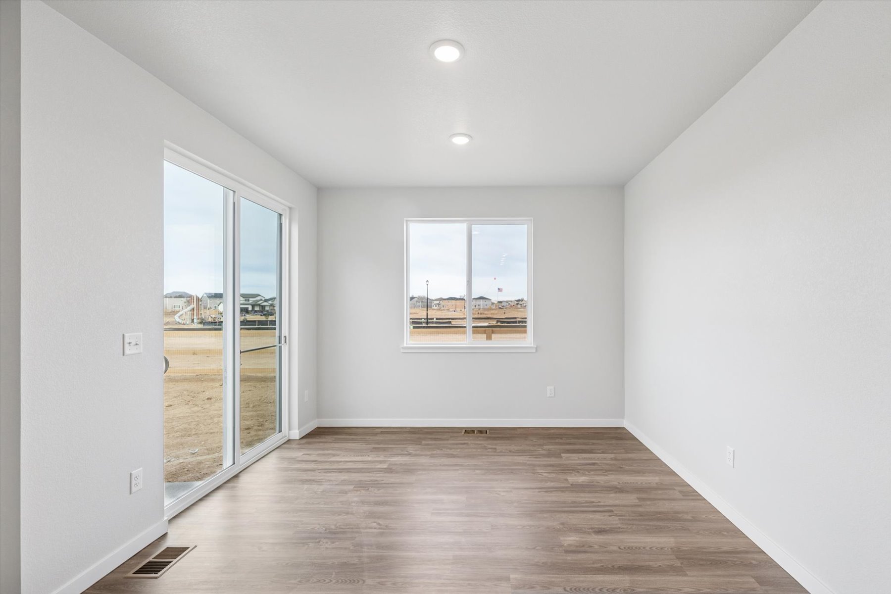 A room with a wood floor and a large window.