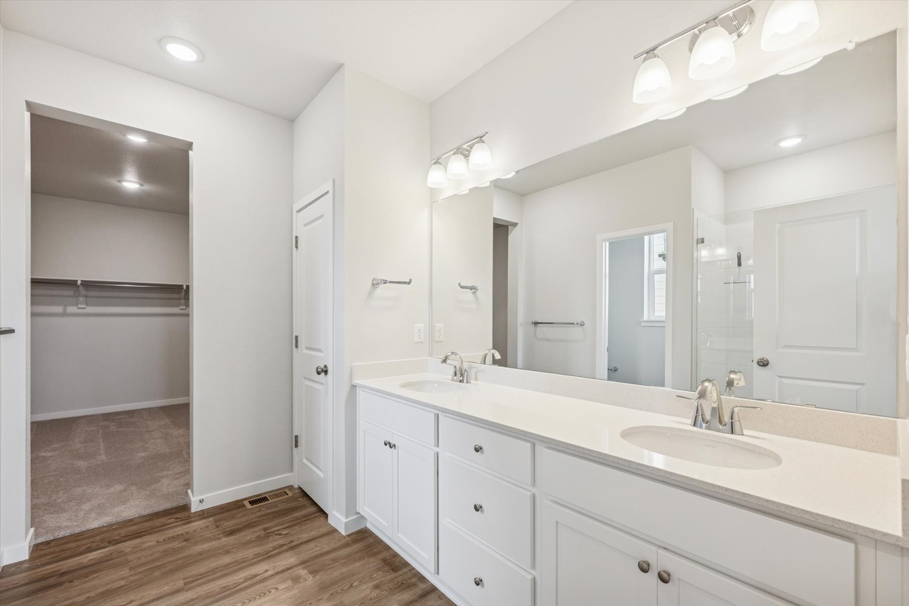 A bathroom with white cabinets.