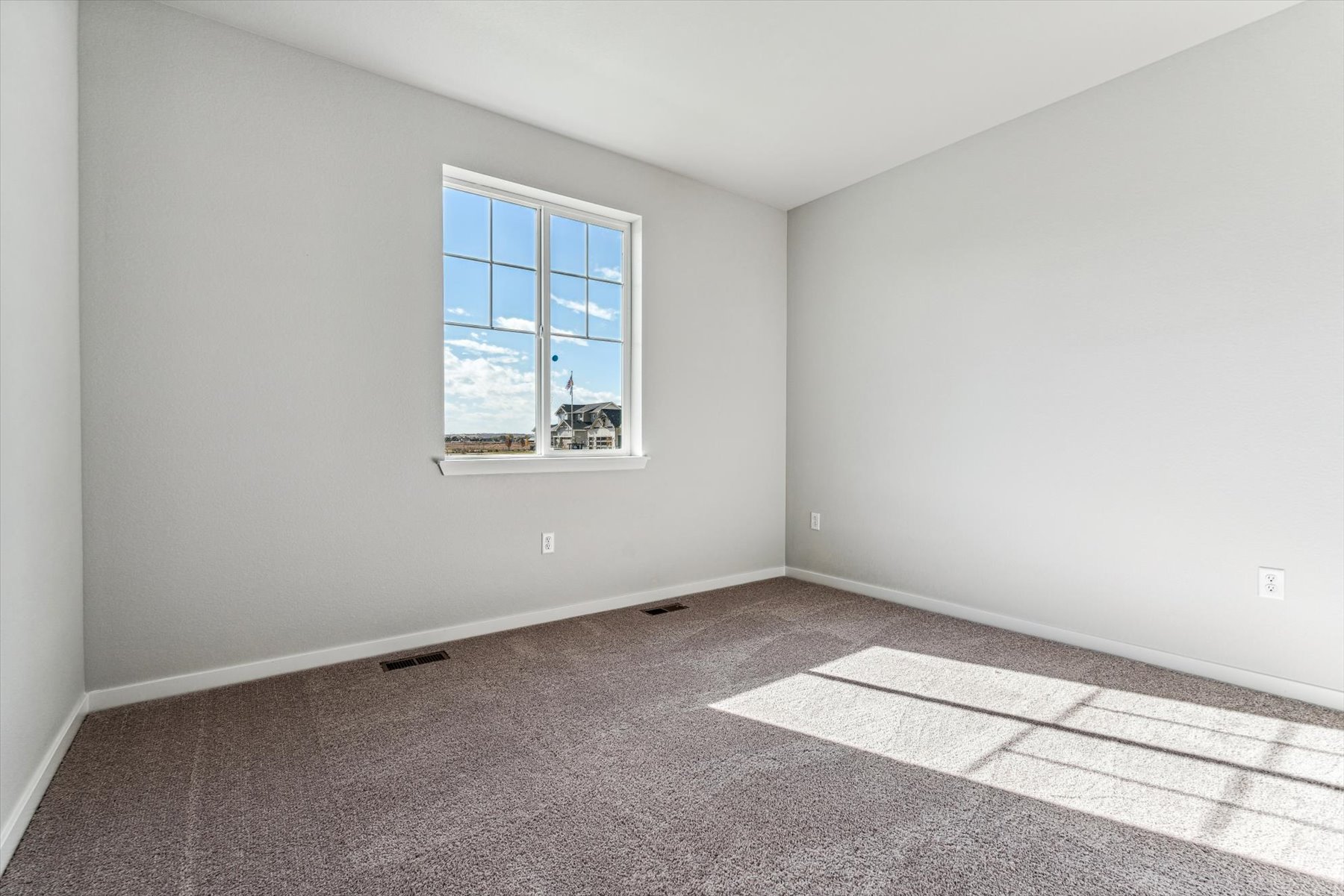 A room with a window and a rug.