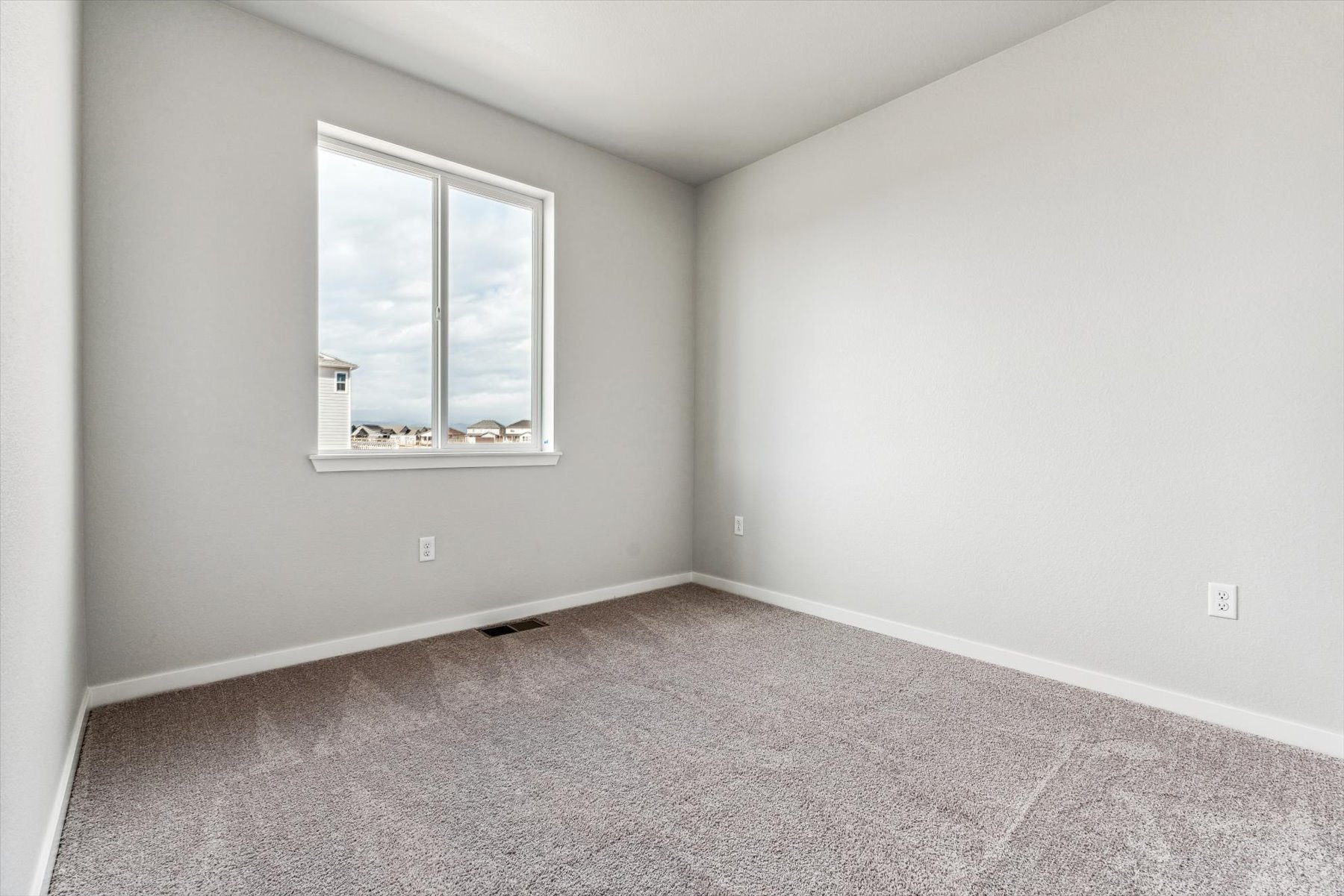 A room with a window and a carpet.