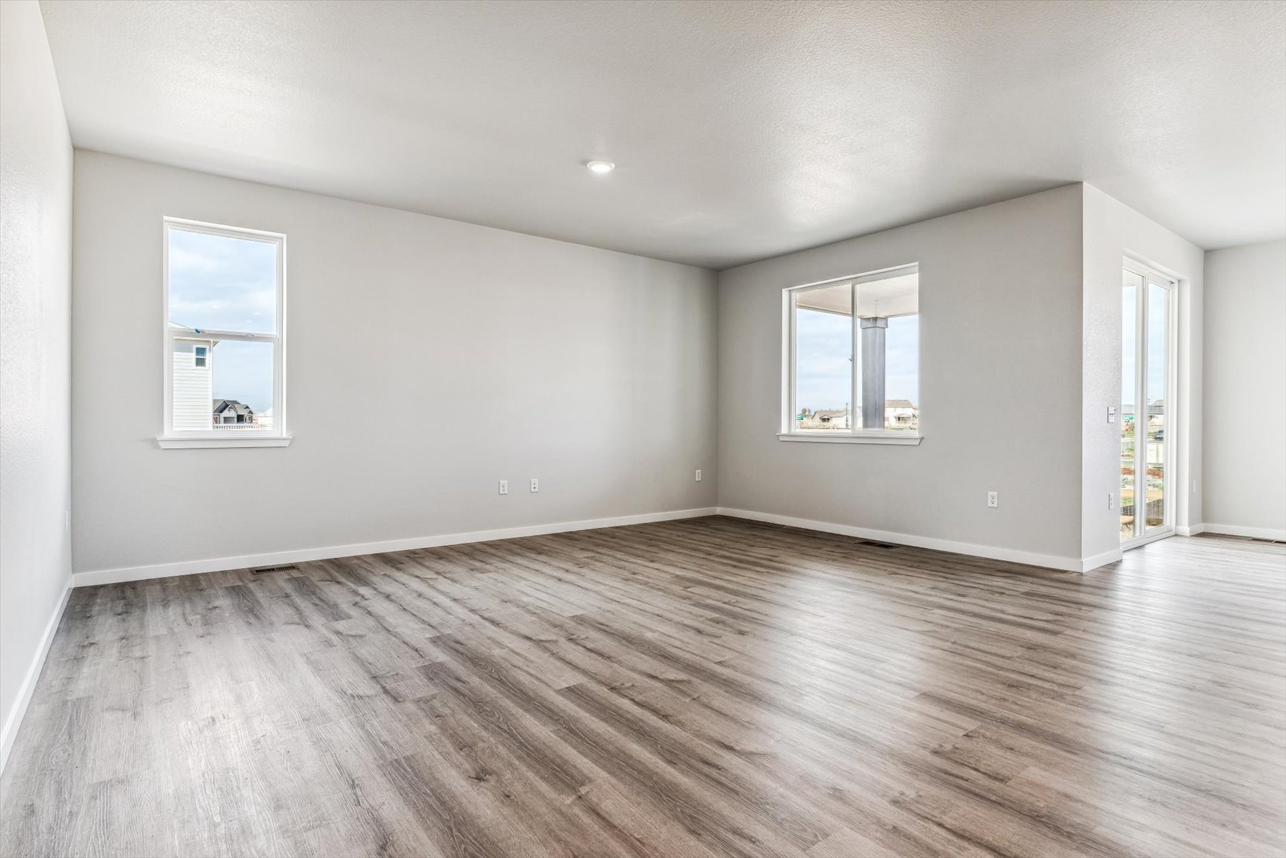 A room with a wood floor and windows.