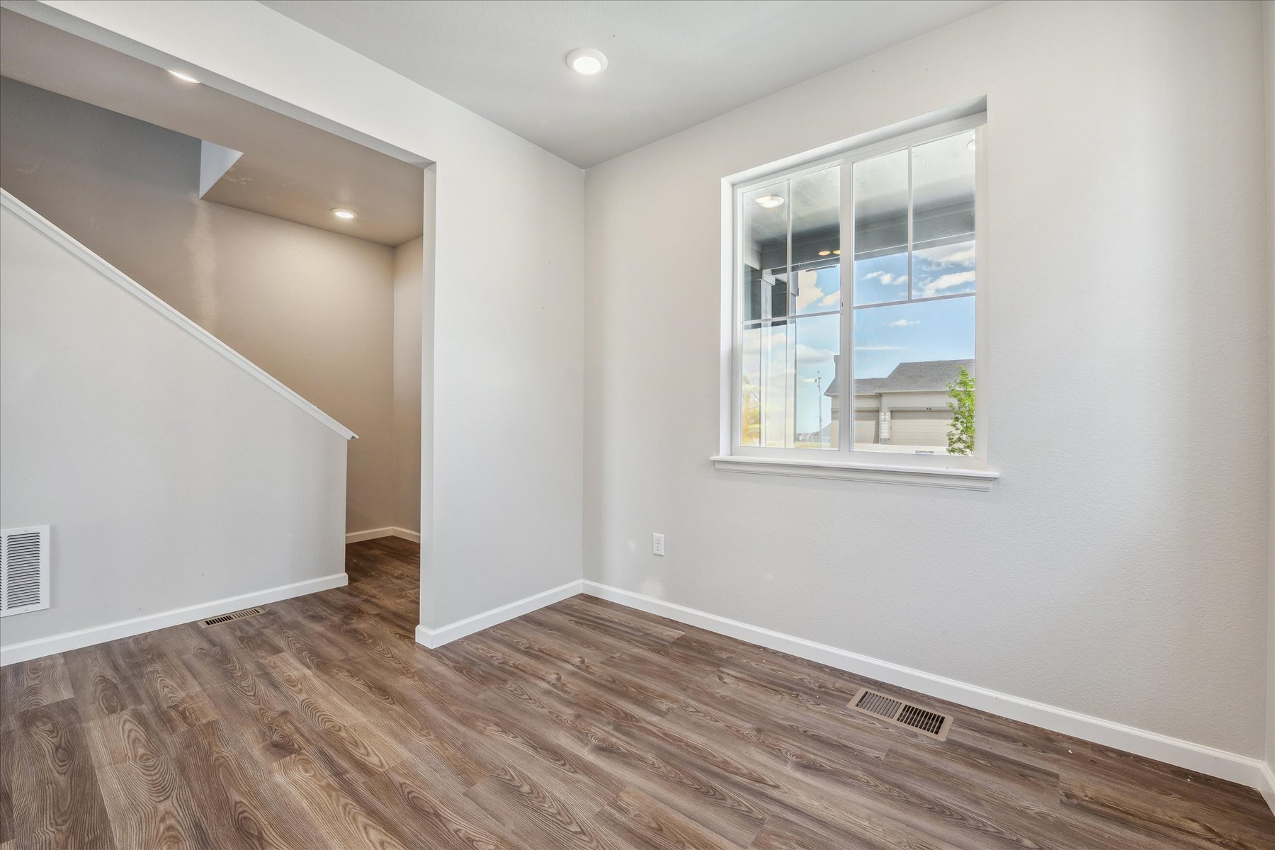 A room with a window and a wood floor.