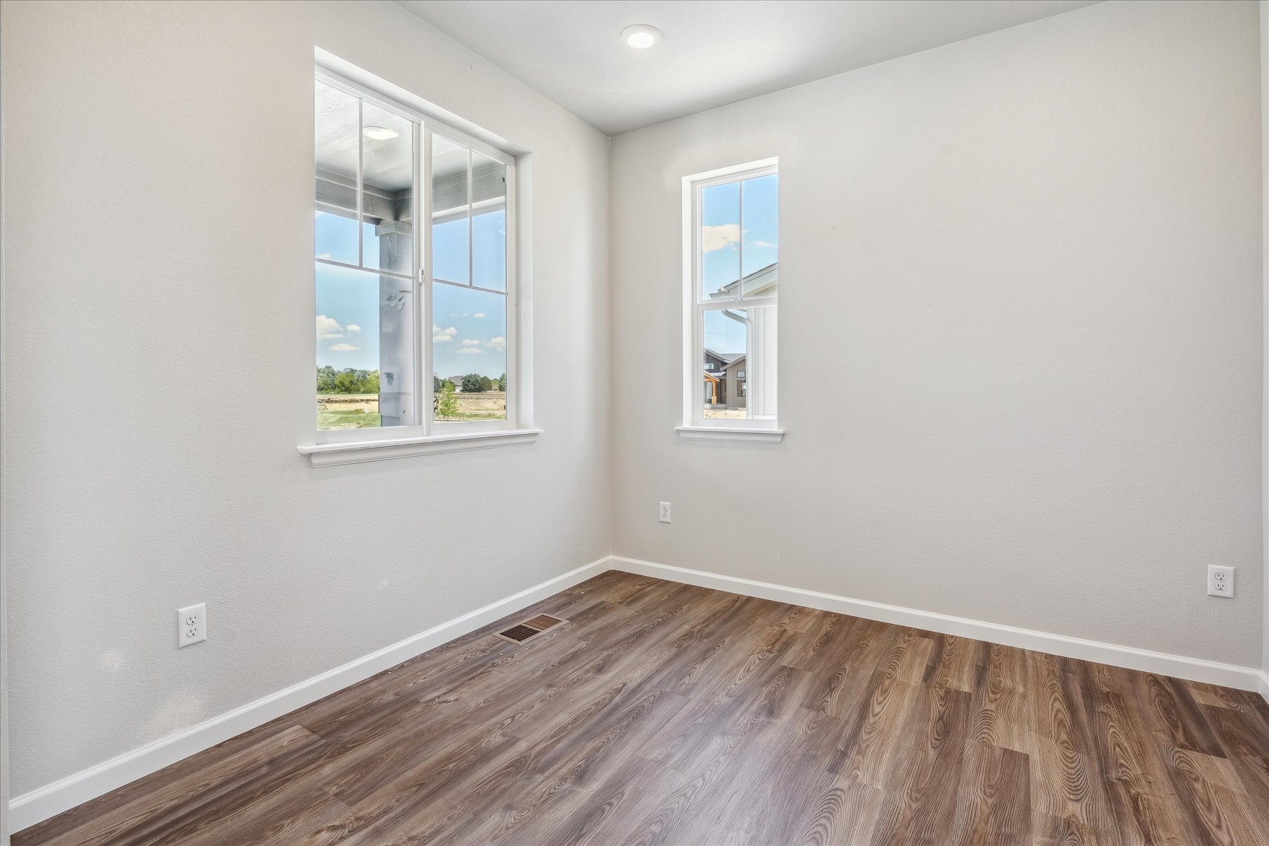 A room with a wood floor and a window with a wood floor.