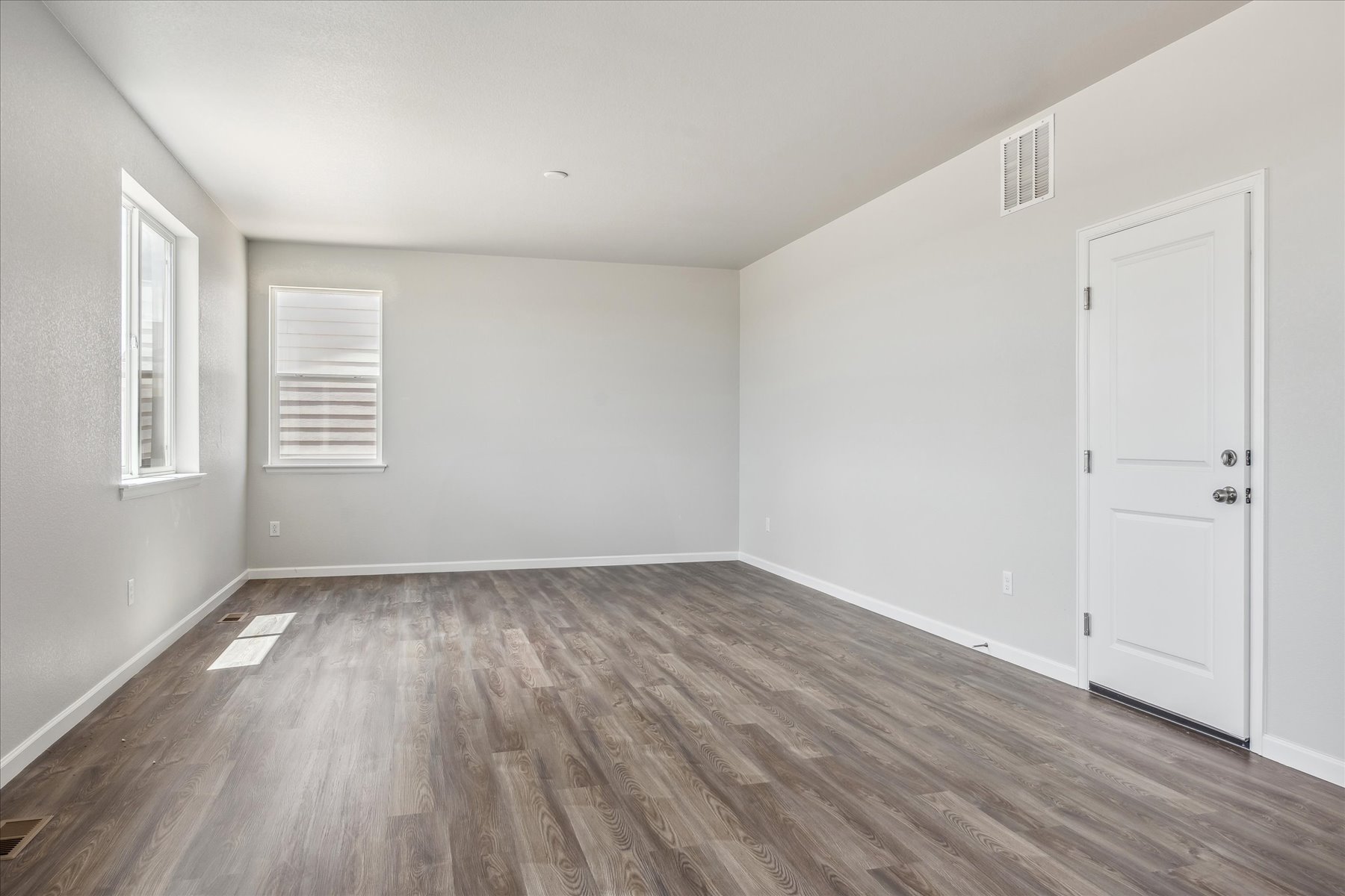 A room with a wood floor and white doors.