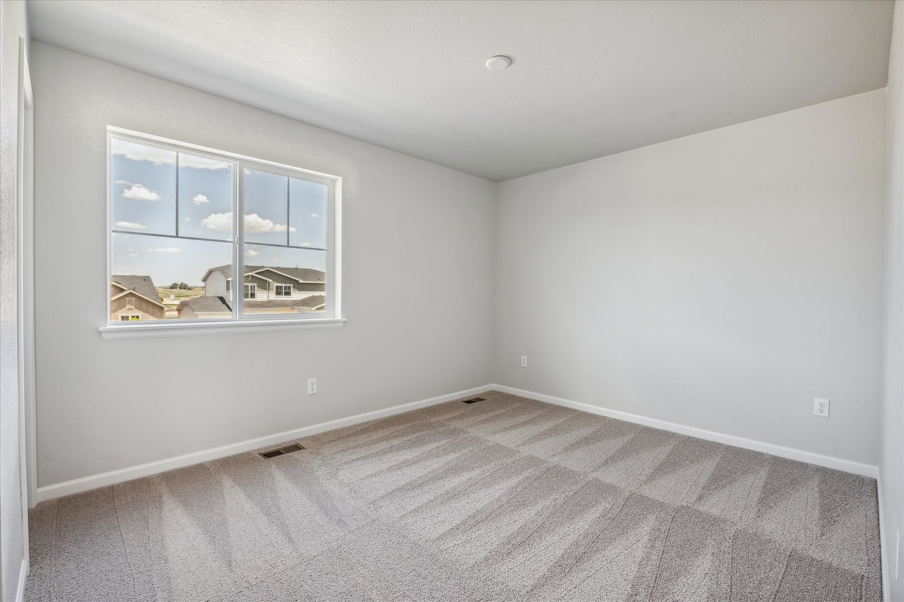 A room with a window and a carpet.